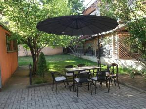 a table and chairs with an umbrella on a patio at Vila Silia in Skopje