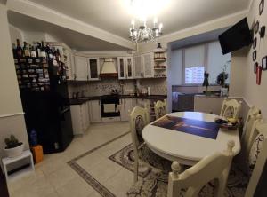 a kitchen with a table and chairs and a dining room at Glamour Apartment in Chişinău +4 photos