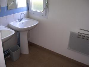 a white bathroom with a sink and a mirror at La Salamandre in Fouras