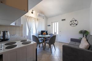 a kitchen and living room with a table and a couch at Apartments Ivo Bozinovic in Tivat