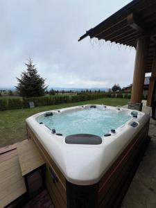 a jacuzzi tub sitting on a deck in a yard at Pirin Golf Villa Relax in Razlog