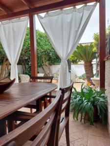 a wooden table and chairs on a patio at La Cycas in Torvaianica