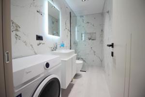 サランダにあるVeseli Luxury Apartmentsの洗面台とトイレを備えた白いバスルーム +18枚の写真