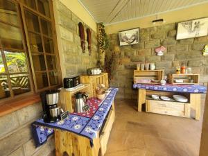 a room with a kitchen with wooden tables and a counter at Edaala Comfort - B&B in Nairobi