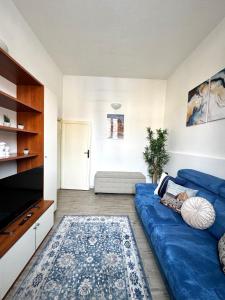 a living room with a blue couch and a tv at Accommodation near the airport in Florence