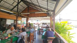 a group of people sitting at tables in a restaurant at Rawai Naiharn 3 bedroom house in Rawai Beach