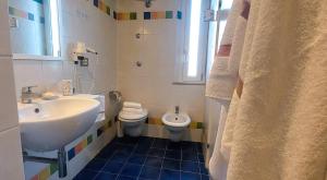 a white bathroom with a sink and a toilet at Hotel Garden B&B in Marotta