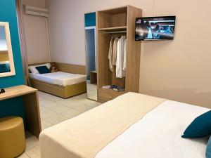 a bedroom with a bed and a tv on the wall at Hotel Garden B&B in Marotta