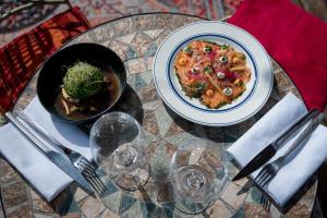a table with a plate of food and a bowl of food at Saint Aubin Logis Hôtel & Restaurant in Saint-Aubin-sur-Mer