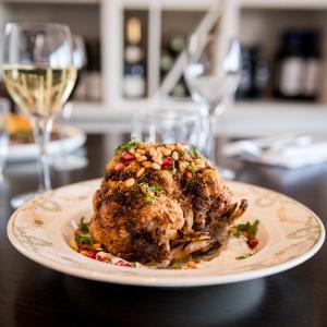 a plate of food on a table with a glass of wine at Saint Aubin Logis Hôtel & Restaurant in Saint-Aubin-sur-Mer