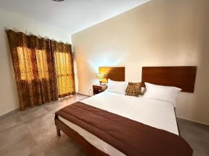 土巴迪亚劳Ecolodge La Grande Tortue - Maison d'hôtes的一间带一张大床和两扇窗户的卧室