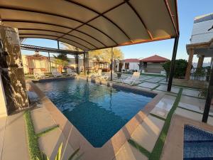 a swimming pool with an umbrella on a house at AlZaeem Resort & Hotels in Barka
