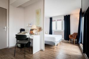 a hotel room with a bed and a desk and chair at Saint Aubin Logis Hôtel & Restaurant in Saint-Aubin-sur-Mer