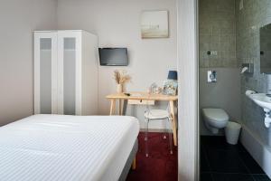 a bedroom with a bed and a sink and a desk at Saint Aubin Logis Hôtel & Restaurant in Saint-Aubin-sur-Mer