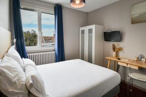 a bedroom with a white bed and a window at Saint Aubin Logis Hôtel & Restaurant in Saint-Aubin-sur-Mer
