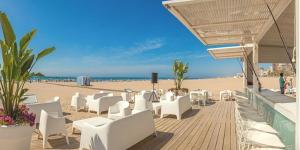 plaża z białymi stołami i krzesłami oraz plaża w obiekcie Apartamento Grau de Gandía con Vistas w mieście Puerto de Gandía