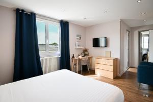 a bedroom with a bed and a desk and a window at Saint Aubin Logis Hôtel & Restaurant in Saint-Aubin-sur-Mer