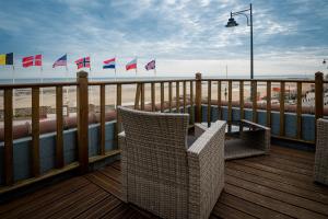a deck with chairs and flags on the beach at Saint Aubin Logis Hôtel & Restaurant in Saint-Aubin-sur-Mer