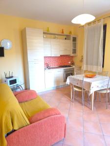a living room with a table and a kitchen at La casetta di Glenda in Favignana