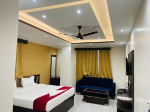 a hotel room with a bed and a blue chair at Hotel D B Palace in Patna +32 photos