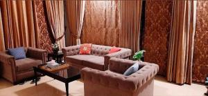 a living room with two couches and a table at Pine park gust house in Bāzār