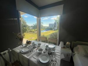 Una mesa con platos y tazas y una ventana. en Suites de Portal, en Paraná