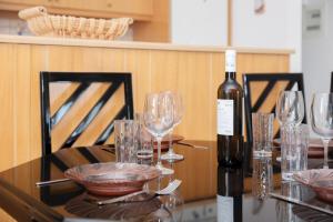 a bottle of wine sitting on a table with glasses at Petralia's Apartment in Skiathos National Airport
