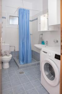 a bathroom with a toilet a sink and a washing machine at Petralia's Apartment in Skiathos National Airport +22 photos