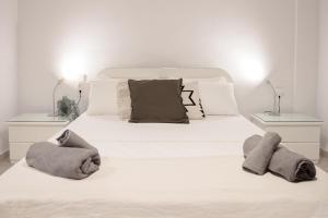 a bedroom with a white bed with towels on it at Petralia's Apartment in Skiathos National Airport