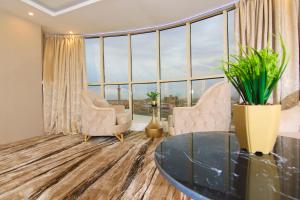 a living room with a table and chairs and large windows at الفخامه بارك in Şabyā