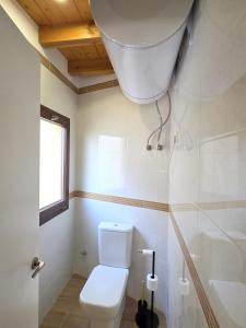 a white bathroom with a toilet and a window at Vivienda Camino de San Martin in Frómista