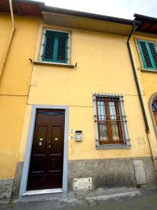 a yellow building with two windows and a door at Accommodation near the airport in Florence