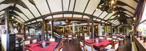 uma sala de jantar com mesas e cadeiras vermelhas em Hotel Manastir Berovo em Berovo