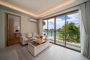 a living room with a table and a large window at now condo near beach 2bedroom in Kamala Beach