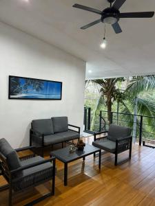 a living room with two couches and a ceiling fan at Hakuna in San Juanillo