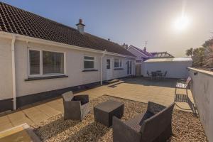 einen Hinterhof mit Stühlen und eine Terrasse mit einem Haus in der Unterkunft The Seahorse Portrush in Portrush