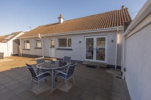 eine Terrasse mit Tisch und Stühlen vor einem Haus in der Unterkunft The Seahorse Portrush in Portrush
