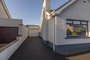 eine Gasse zwischen zwei Gebäuden mit einer Garage in der Unterkunft The Seahorse Portrush in Portrush