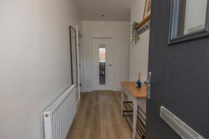 einen Flur mit Tür und Tisch in einem Zimmer in der Unterkunft The Seahorse Portrush in Portrush