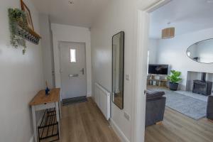 ein Wohnzimmer mit weißen Wänden und einem Flur in der Unterkunft The Seahorse Portrush in Portrush + 26 Fotos