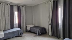 Un dormitorio con dos camas y dos ventanas. en Villa GEMMA, en Castel Volturno 18 fotos más