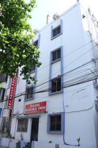 a white building with a red sign on it at Park kasba Inn in Kolkata