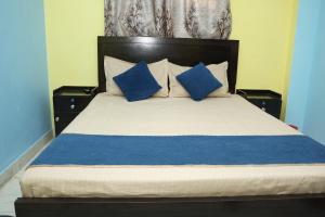 a bedroom with a bed with blue and white pillows at Park kasba Inn in Kolkata