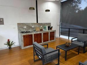 a living room with two chairs and a kitchen at Hakuna in San Juanillo