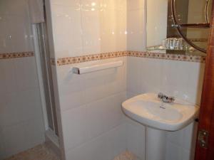 a white bathroom with a sink and a shower at Hotel Avenida Baiona in Baiona