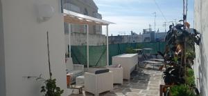 a balcony with white furniture and plants on a building at B&B CASAVACANZE CHIESA MADRE in Carovigno
