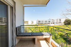 a bench sitting on a balcony with a view at Annas Apartment Kalithea in Kallithea Halkidikis