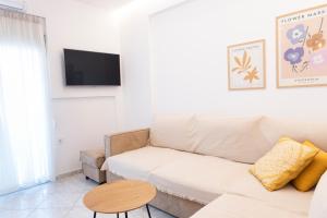 a living room with a couch and a tv at Annas Apartment Kalithea in Kallithea Halkidikis
