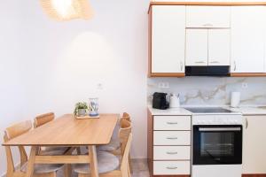 a kitchen with a wooden table and a dining room at Annas Apartment Kalithea in Kallithea Halkidikis