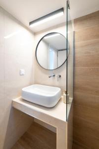 a bathroom with a white sink and a mirror at Annas Apartment Kalithea in Kallithea Halkidikis +6 photos